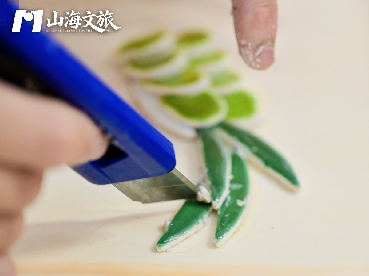 非遗嵌瓷研学：师傅示范用刀把彩色瓷片剪出花瓣形，为拼贴嵌瓷图案做准备